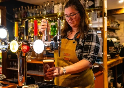 A member of staff pulling a pint behind the bar at The Murray Arms.