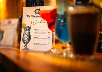 The printed cocktail menu card displayed on the bar.
