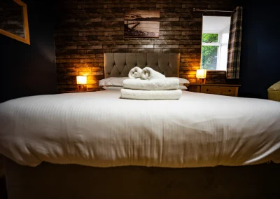 Double bedroom at Thorshaven Apartment with bedside lamps and a view over the garden