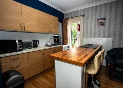 Kitchen and breakfast bar at Thorshaven Apartment with doors to the garden